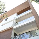 Modern home featuring WPC wall cladding, fluted panels, and glass balconies.