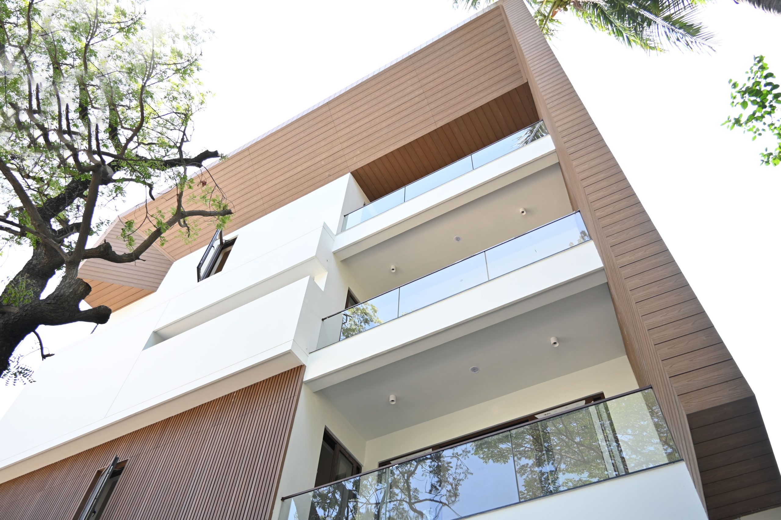 Modern home featuring WPC wall cladding, fluted panels, and glass balconies.
