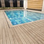 Swimming pool with stylish WPC decking for durable outdoor flooring.